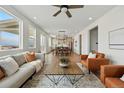 Bright living room with modern furniture, a ceiling fan, and an open floor plan that seamlessly connects to the kitchen at 1136 Hillside Ln, Louisville, CO 80027