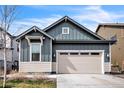 Stylish two-car garage home exterior with blue vertical siding and beige horizontal siding at 6311 Stable View St, Castle Pines, CO 80108