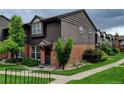 Attractive townhome exterior featuring brick facade, wood siding, manicured lawn, and sidewalk entrance at 3855 S Monaco St # 177, Denver, CO 80237