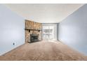 Bright living room featuring a cozy fireplace and sliding glass doors to the balcony at 14182 E Colorado Dr # 204, Aurora, CO 80012
