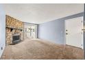 Spacious living room with a stone fireplace and sliding doors to a balcony at 14182 E Colorado Dr # 204, Aurora, CO 80012