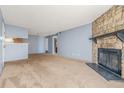 Open-concept layout featuring fireplace, neutral carpet, and access to other rooms at 14182 E Colorado Dr # 204, Aurora, CO 80012