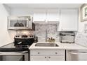 Well-maintained kitchen features stainless steel appliances, stone backsplash, and white cabinetry at 1020 15Th St # 9K, Denver, CO 80202