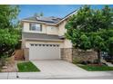 Two story home featuring stone accents, attached two car garage and well maintained lawn at 10696 Riverbrook Cir, Highlands Ranch, CO 80126