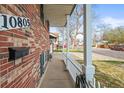 A charming front porch view with brick detail and white picket fence at 10805 Verna Ln, Northglenn, CO 80234