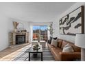 Inviting living room with a cozy fireplace, comfortable seating, and large windows that offer a view to the outdoor scenery at 1818 S Quebec Way # 2-3, Denver, CO 80231