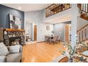 Open-concept living area features a fireplace, hardwood floors, and staircase at 8304 S Upham Way, Littleton, CO 80128