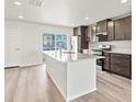 Bright kitchen with large island, stainless steel appliances, and dark cabinets at 14412 Pansy Loop, Morrison, CO 80465