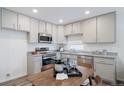 Modern kitchen with stainless steel appliances, granite countertops, and stylish gray cabinets at 46542 Avery Ln, Bennett, CO 80102