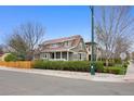 Attractive two-story home with a welcoming front porch, manicured bushes, and a beautiful blue sky at 2595 S Adams St, Denver, CO 80210
