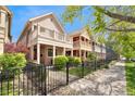 Street view of homes featuring welcoming front porches and landscaped lawns secured by black fences at 2222 N Washington St, Denver, CO 80205