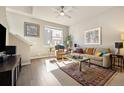 Bright living room with hardwood floors, large window, and comfortable furnishings at 538 S Upham St, Lakewood, CO 80226