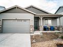 Charming single-story home with a two-car garage and a cozy front porch with stone accents at 121 S Vandriver Way, Aurora, CO 80018
