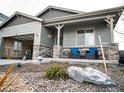 Charming single-story home with a two-car garage and a cozy front porch with stone accents at 121 S Vandriver Way, Aurora, CO 80018