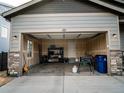Spacious two-car garage featuring ample storage space, a work table and a side door at 121 S Vandriver Way, Aurora, CO 80018