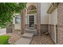 Inviting entryway features a striking arched window above the front door, framed by brick accents and stone landscaping at 9602 Indian Wells Dr, Lone Tree, CO 80124