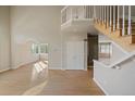 Bright living room featuring soaring ceilings, large windows offering ample natural light, and hardwood floors at 9602 Indian Wells Dr, Lone Tree, CO 80124