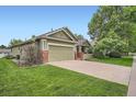 Well-maintained green home with a lush lawn and mature trees at 1851 S Marshall Cir, Lakewood, CO 80232