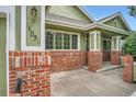 Inviting covered front porch featuring brick columns and tile flooring at 1851 S Marshall Cir, Lakewood, CO 80232