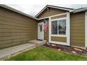 Inviting entryway featuring a storm door, fresh paint and manicured landscaping at 13072 Westlake Pl, Broomfield, CO 80020