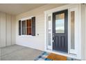 Home's front door featuring a black door with glass inserts and sidelights at 5693 Missoula Trl, Castle Rock, CO 80108