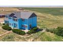 Two-story light blue house with landscaping, on a large lot at 8441 Flint Ridge St, Bennett, CO 80102