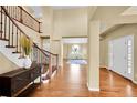 Inviting foyer with wood floors, grand staircase, and natural light at 17826 E Cloudberry Dr, Parker, CO 80134