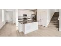 Open kitchen featuring white cabinets, stainless steel appliances, and an island at 537 Nightsky St, Erie, CO 80516