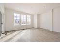 Bright, empty living room with hardwood floors and large windows at 537 Nightsky St, Erie, CO 80516
