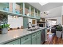 Bright kitchen area with open shelving, sink with black faucet, and hardwood floors with view to Gathering room at 7770 W 87Th Dr # F, Arvada, CO 80005