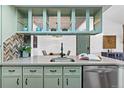 Kitchen with green cabinets, stainless steel appliances, and open shelving showing view to dining area at 7770 W 87Th Dr # F, Arvada, CO 80005