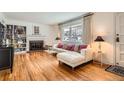 Bright living room with hardwood floors, fireplace, large window, and comfortable white sectional sofa at 1748 S Locust St, Denver, CO 80224