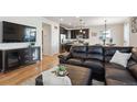 Living room with hardwood floors, sectional sofa, and view of kitchen at 4841 S Picadilly Ct, Aurora, CO 80015