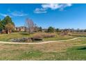 Scenic community green space with a pond, walking path, mature trees, and surrounding homes in the background at 4070 S Atchison Way # 203, Aurora, CO 80014