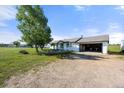 Well-maintained single story house featuring a large yard and an attached garage with a gravel driveway at 1788 Shoshone Trl, Elizabeth, CO 80107