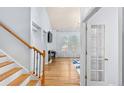 Bright foyer showcasing hardwood floors, a staircase with wooden railings, and an inviting doorway ahead at 19118 E Grand Cir, Aurora, CO 80015