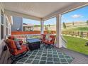 Relaxing covered deck with stylish outdoor furniture and a view of the expansive backyard at 6174 Flattop St, Golden, CO 80403