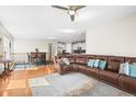 Open-concept living room and dining area featuring hardwood floors and a comfortable leather sofa at 6174 Flattop St, Golden, CO 80403