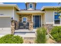 Close up of the front porch with stone pillars, rocking chairs, and a well-maintained landscape at 21855 E Idyllwilde Dr, Parker, CO 80138