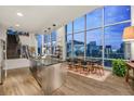 Modern kitchen featuring a stainless steel island, sleek cabinetry, hardwood floors, and large windows with stunning city views at 55 W 12Th Ave # 608, Denver, CO 80204