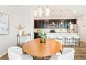 Bright dining room with modern chandelier, sleek furniture, and kitchen view at 6041 N Orleans St, Aurora, CO 80019