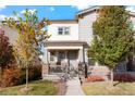 Inviting two-story home featuring a charming front porch, stone accents, and well-maintained landscaping at 6041 N Orleans St, Aurora, CO 80019