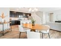 Bright, open kitchen with dark cabinets, stainless steel appliances, and an island overlooking the dining area at 6041 N Orleans St, Aurora, CO 80019