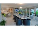 Elegant dining area with stylish table, modern light fixture, and seamless access to outdoor space at 1175 S Jackson St, Denver, CO 80210