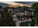 Aerial front view of a modern home with expansive windows, deck, professional landscaping, and inviting walkway at 1175 S Jackson St, Denver, CO 80210