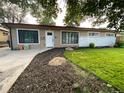 Single-story home with manicured lawn and rock-lined flower beds at 6139 Broadway S, Littleton, CO 80121