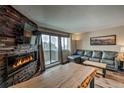 Bright living room offers a fireplace, tv, leather couch and a sliding door to the balcony at 611 Village Rd # 620, Breckenridge, CO 80424