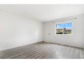 Bright bedroom with wood-look floors, a large window, and a convenient door for easy access at 5711 W 92Nd Ave # 47, Westminster, CO 80031