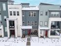 Aerial view of modern townhomes showcasing their architectural details, red doors and snow-covered surroundings at 10088 E 62Nd Ave, Denver, CO 80238