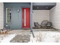 Inviting front porch with modern seating, a bright red door, and contemporary design elements at 10088 E 62Nd Ave, Denver, CO 80238